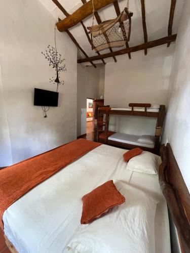 1 dormitorio con 1 cama grande y 1 litera en Hostería Doña Vivi, en Barichara