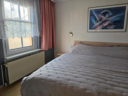 ein Schlafzimmer mit einem weißen Bett und einem Fenster in der Unterkunft Haus Alva in Ahlbeck