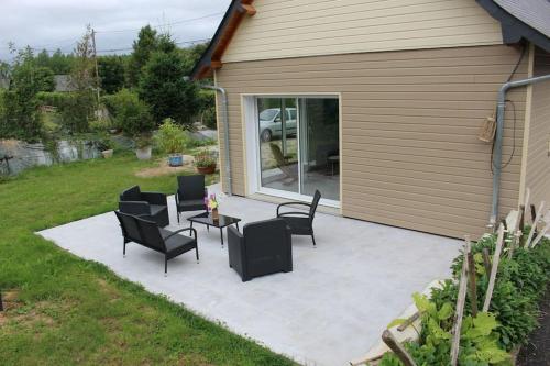 une terrasse avec des chaises noires et une table. dans l'établissement Maison en Normandie, à Londinières