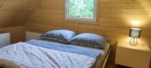 Posto letto in una baita di tronchi con finestra. di Domek letniskowy Nad Mrowinkiem a Rybakowo