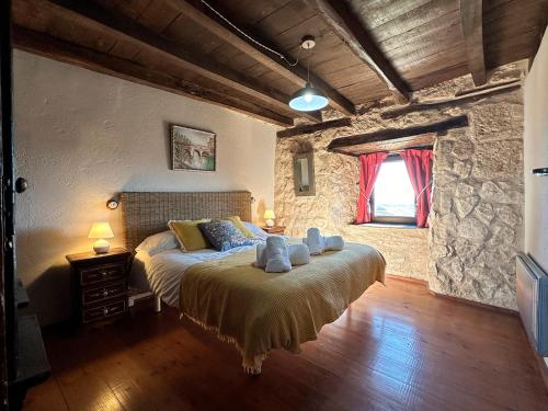 a bedroom with a bed and a stone wall at Casa Rural Muralla de Haza in Haza