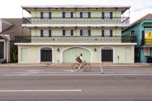 a man riding a bike down a street in front of a building at French Quarter Suites Hotel in New Orleans