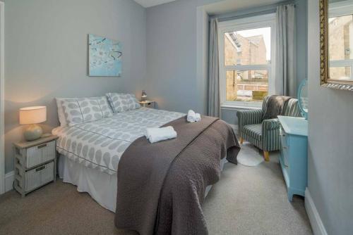 una camera con un letto e una sedia e una finestra di The Seagull Apartment a Cowes