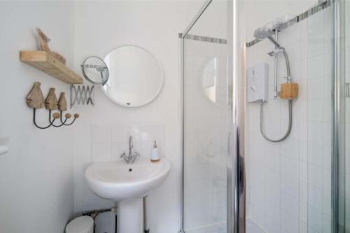 bagno bianco con lavandino e doccia di The Seagull Apartment a Cowes