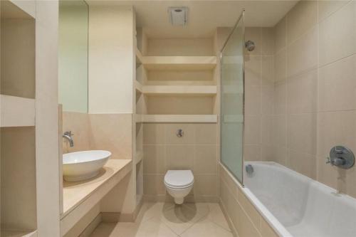 a bathroom with a toilet and a sink and a bath tub at Penthouse Canary Wharf - Free WiFi in London