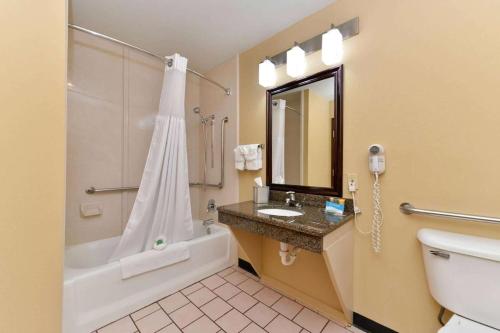 a bathroom with a toilet and a sink and a shower at Baymont by Wyndham Ardmore I-35 in Ardmore