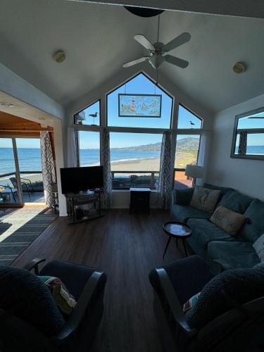 a living room with a view of the ocean at Oceanfront Cabin 4 With Jacuzzi & Stunning Views in Smith River