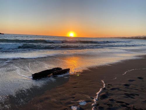 a discarded item on the beach at sunset at Oceanfront Cabin 4 With Jacuzzi & Stunning Views in Smith River