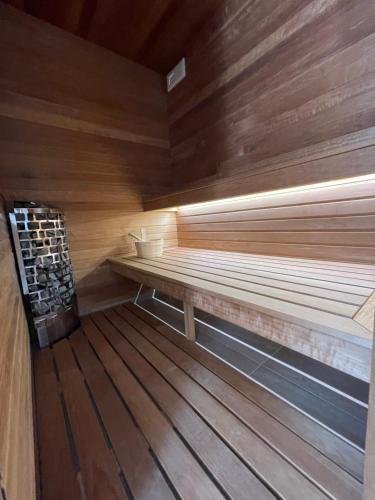 a sauna with a wooden floor and a bench at Vitality Apartman in Makó
