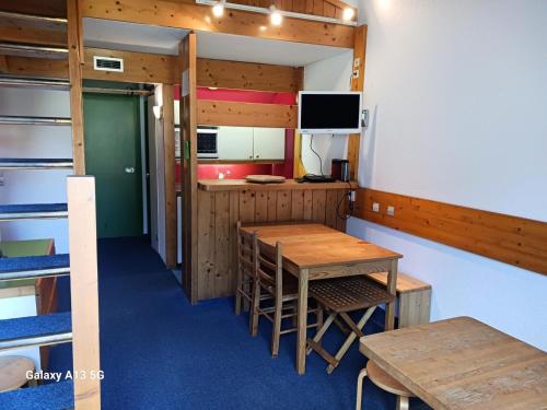 une pièce avec une table, des chaises et une télévision dans l'établissement Résidence Tournavelles - Appartement 2 pièces 7 personnes en duplex, au pied des pistes et des commerces, proche de l'ESF et de la garderie dans le villa MAE-5091, à Arc 1800