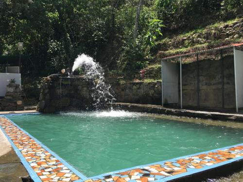 una piscina con fontana al centro di Madera Verde Ecolodge a Maranura