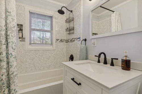 ein weißes Badezimmer mit einem Waschbecken und einem Spiegel in der Unterkunft Valley Vista-Mins to SkylineDrive-Hot Tub-King, Queen Beds in Front Royal