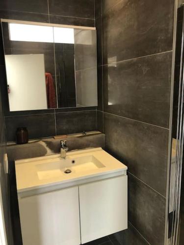 La salle de bains est pourvue d'un lavabo blanc et d'un miroir. dans l'établissement Unique Space for great stays, à Bruxelles