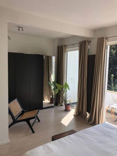 - une chambre avec un lit, une chaise et des fenêtres dans l'établissement Unique Space for great stays, à Bruxelles