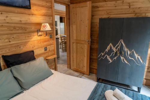 a bedroom with a bed and a wooden wall at Résidence Pramouton - Chalets pour 6 Personnes 601 in Le Mélézet