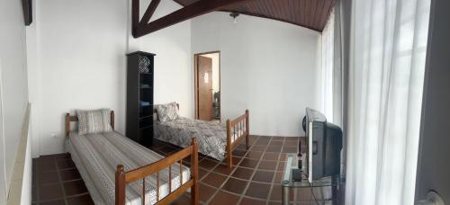 a living room with a couch and a tv at Hospedagem Casa da Rê in Salto