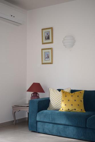 T&L Apartments Agiaos Tychonas في ليماسول: أريكة زرقاء في غرفة المعيشة مع طاولة