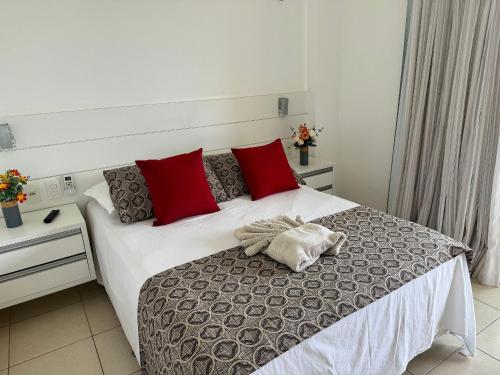 a bedroom with a large bed with red pillows at Apto. Beverlly Hills, Próx. Beach Park in Aquiraz