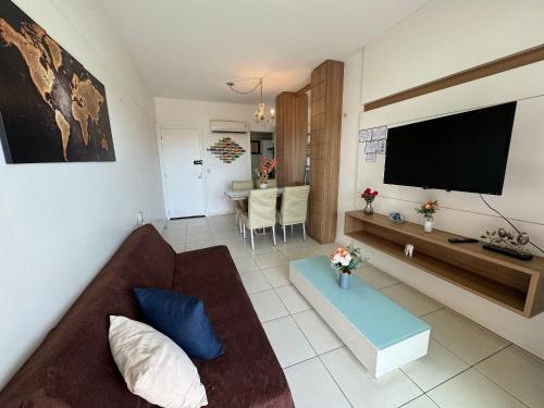 a living room with a couch and a flat screen tv at Apartamento Beverly Hills - Próximo ao Beach Park in Aquiraz