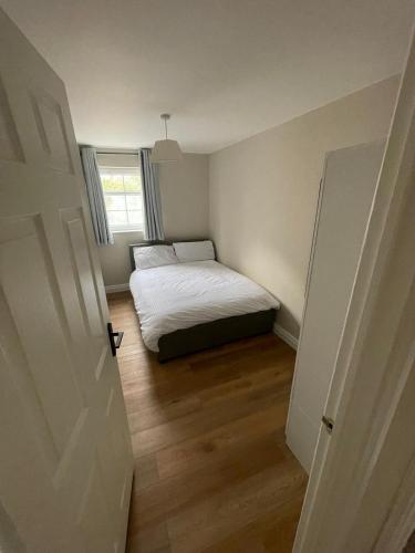 a small bedroom with a bed and a window at Luxurious apartment Gilnahirk in Belfast