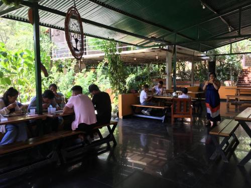 un gruppo di persone seduti ai tavoli in un ristorante di Madera Verde Ecolodge a Maranura