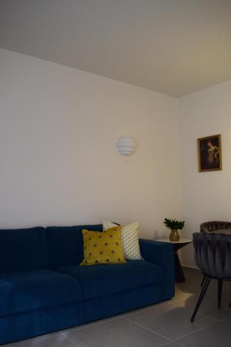 Sofá azul en la sala de estar con mesa en T&L Apartments Agiaos Tychonas, en Limassol
