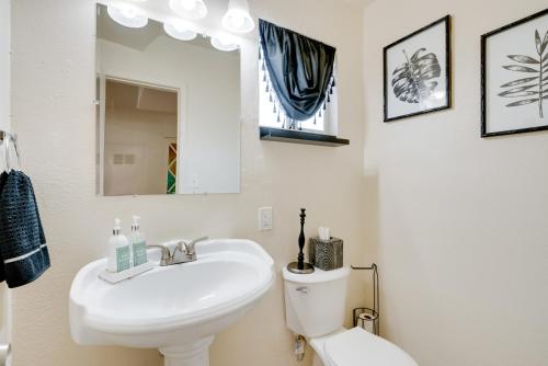 a bathroom with a sink and a toilet and a mirror at Breezy Fresno Home - Near Airport and Downtown in Fresno