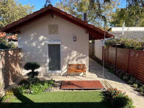 a bench sitting in a yard next to a house at Vitality Apartman in Makó