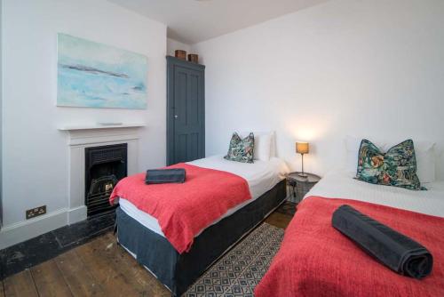 2 Betten in einem Zimmer mit Kamin in der Unterkunft Westhill, Cowes Town House in Cowes