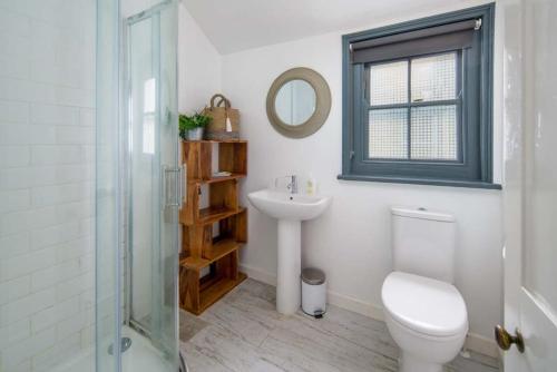 ein Badezimmer mit einem WC, einem Waschbecken und einem Spiegel in der Unterkunft Westhill, Cowes Town House in Cowes