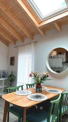 comedor con mesa de madera y sillas verdes en A Casa da Mariana, en Casa Nova
