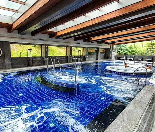a large swimming pool with two hot tubs in it at 6 Luxury SPA Apartments TOP resort Bansko - incl wellness in Bansko