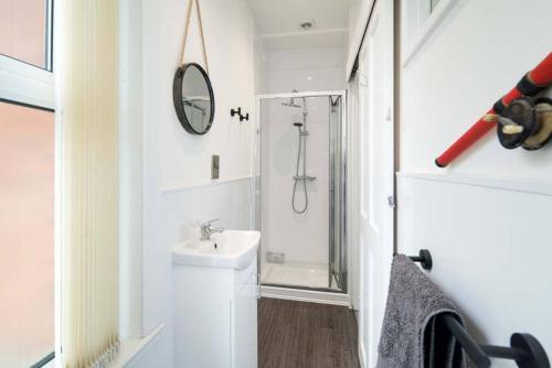 uma casa de banho branca com um lavatório e um chuveiro em Wheatsheaf House, Cowes em Cowes