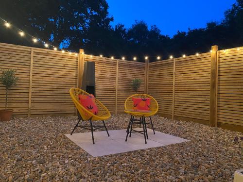twee gele stoelen naast een hek met lichten bij Little Mount, Rye in Rye