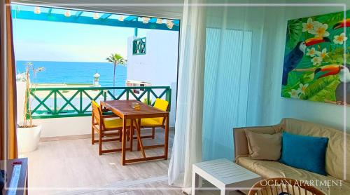 een woonkamer met een tafel en uitzicht op de oceaan bij Ocean Apartment Gran Canaria in Maspalomas