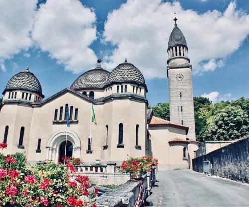 a building with two domes and a clock tower at Appartement Cosy centre-ville in Ribérac