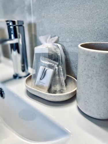 un comptoir blanc avec une tasse et quelques ustensiles dans l'établissement Appartement Cosy centre-ville, à Ribérac