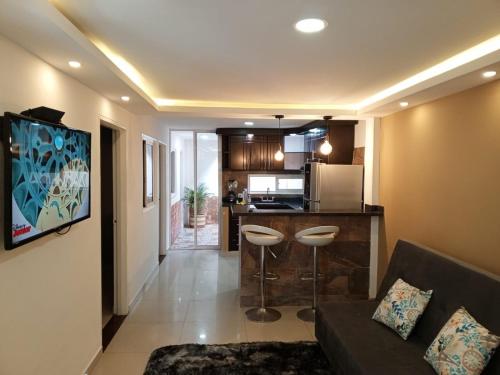 ein Wohnzimmer mit einem Sofa und einer Küche in der Unterkunft Apartamento Torres del Castillo in San Gil