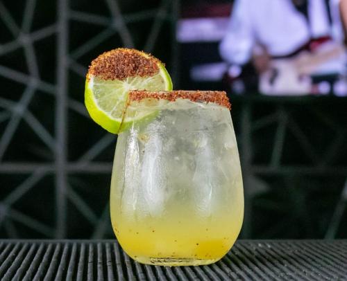 a drink with a slice of lime on a table at HOTEL CLUB MORAZAN in San Lorenzo