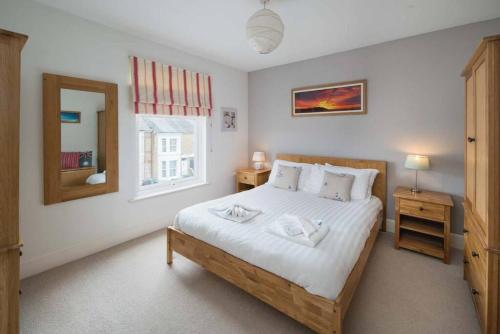 um quarto com uma cama, um espelho e uma janela em Windward cottage, a great 3bed house in Cowes em Cowes