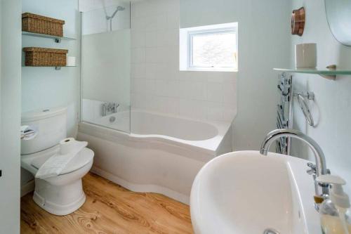 a bathroom with a toilet and a tub and a sink at Windward cottage, a great 3bed house in Cowes in Cowes