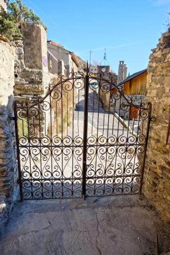 un portail en fer dans une ruelle avec une rue dans l'établissement Mountain Village Studio en Nohèdes pour 2, à Nohèdes
