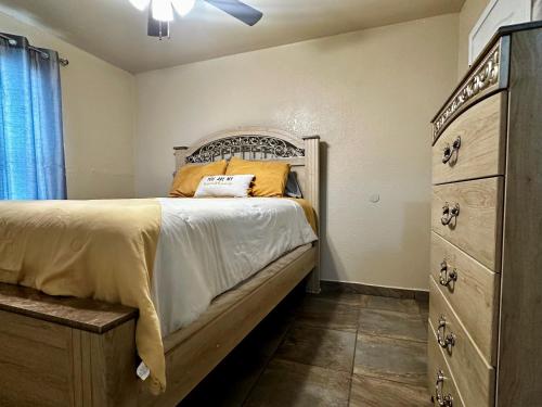 a bedroom with a large bed and a dresser at The Rustic @ Paseo de Encinal Drive in Eagle Pass