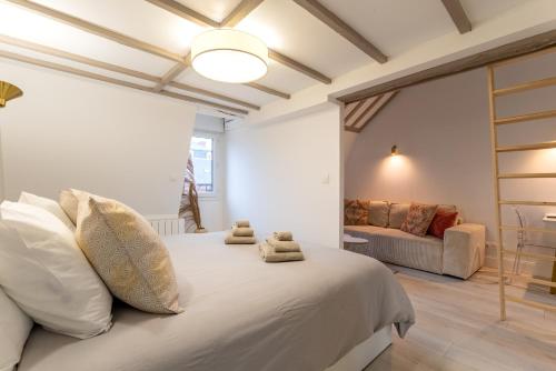 une chambre avec un grand lit blanc et un canapé dans l'établissement Suite Cathédrale haut de gamme + Parking - N°8, à Rouen