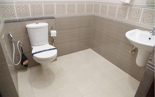 a bathroom with a toilet and a sink at Hotel ABM International in Bangalore