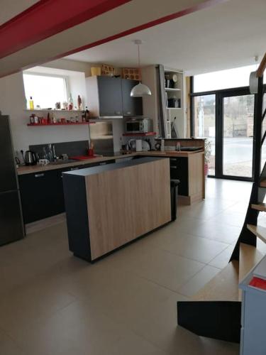 - une cuisine avec un îlot au milieu d'une pièce dans l'établissement Maison entière au cœur des vignes des Trois Bacchantes !, à Saint-Étienne-la-Varenne