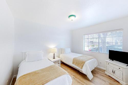 Duas camas num quarto branco com televisão em La Marsielle 256 em Pismo Beach