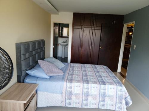 1 dormitorio con 1 cama con edredón azul en Apartamento Torres del Castillo en San Gil
