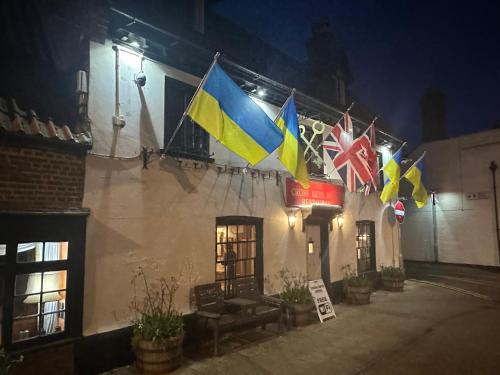 a group of flags hanging from the side of a building at Cross Keys Hotel Chatteris in Chatteris