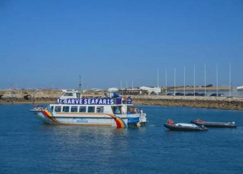 a boat in the water with two small boats at Romeu in Quarteira